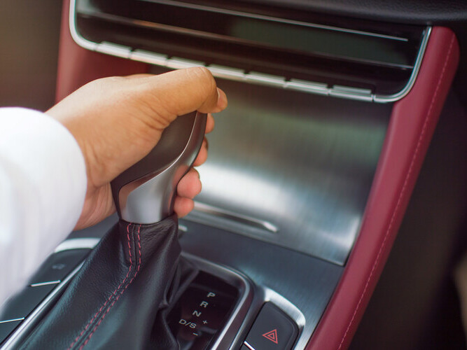 A man driving a car transmitting car gear