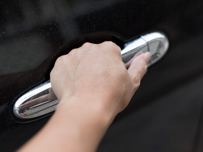Woman hand holding car door handle