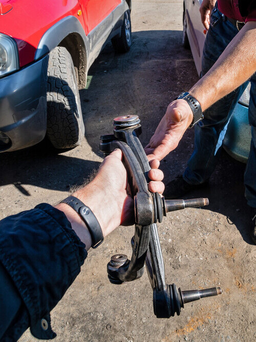 mechanic handing over a car control arm