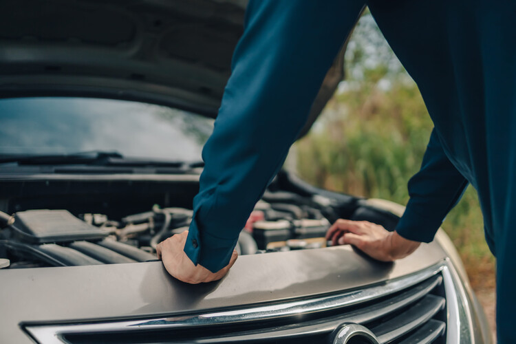 Serious man front of car breakdown and open hood on roadside. Car broken concept.
