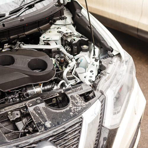 A car with an open hood in service