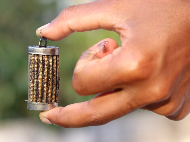 man's hand holding a dirty fuel filter