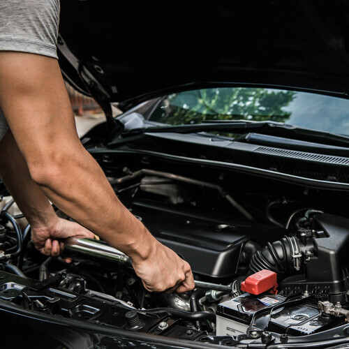 Hand of mechanic is repairing car engine